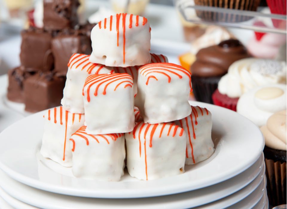 Cake bites stacked on a plate with other desserts by Green Mill Catering