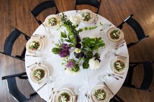 Round table with salad at each place setting by Green Mill Catering